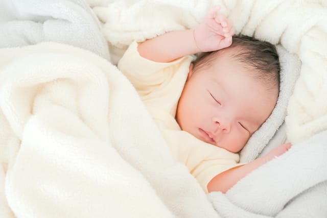 毛布にくるまれて眠る赤ちゃんの様子